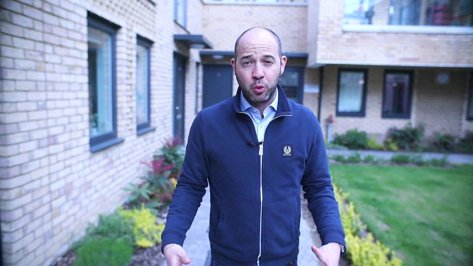 Presenter speaking to camera outside the London Mews Finchley development